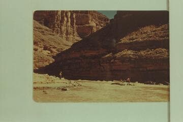 Miscue by George Wing on his first trip in 1947, May which set Nevills's antipathy. The punt is hung on the rock. The other three boats have landed and Nevills is standing on shore giving instructions to Wing. Flow is less than 1100 cfs