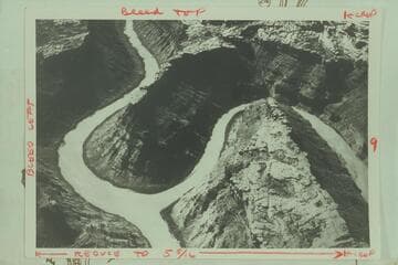The confluence of the Green and Colorado Rivers. The Green River enters from right. The Colorado (formerly the Grand) flows up into the picture from lower left and the combined river moves into the Cataract Canyon at upper left