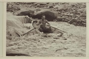 Norm Nevills at 13-Foot Rapid, San Juan River. The boat is one of Ansel Hall's folding spruce skiffs. The flow in the river is less than 400 cfs