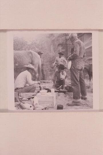 Masland waits for pancakes at camp at head of middle fork of 73. Tom Daly is cooking, Tobe Owl is back of the horse and Dan Lehi looks at Buster Ordiway