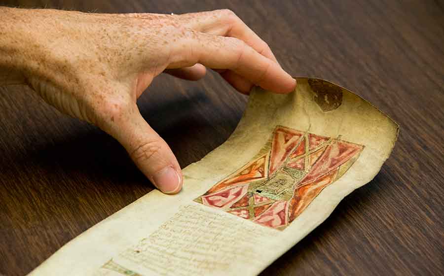 The Huntington Library’s manuscript of a 15th-century English poem written on a scroll of parchment approximately four inches wide and five feet long. The illustration and opening lines of the poem depict the Christological artifact known as Veronica’s veil. Christ’s face is just visible in the center of the image. Photograph by Kate Lain. The Huntington Library’s manuscript of a 15th-century English poem written on a scroll of parchment approximately four inches wide and five feet long. The illustration and opening lines of the poem depict the Christological artifact known as Veronica’s veil. Christ’s face is just visible in the center of the image. Photograph by Kate Lain.